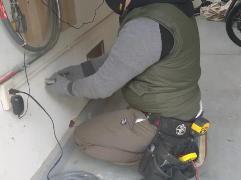 Electrician performing outlet wiring in a Crescent City garage